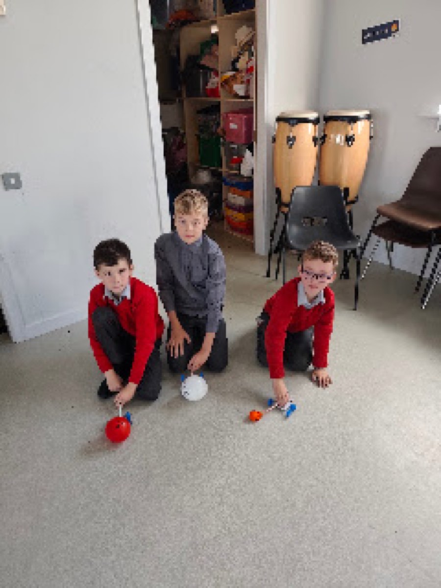 Pupils testing the balloon cars they built in the halla
