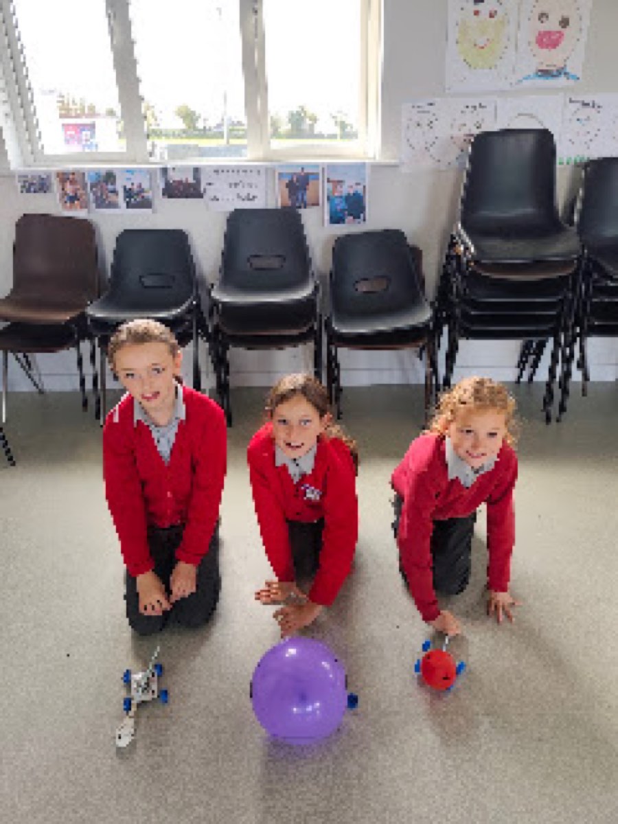 Pupils testing the balloon cars they built in the halla