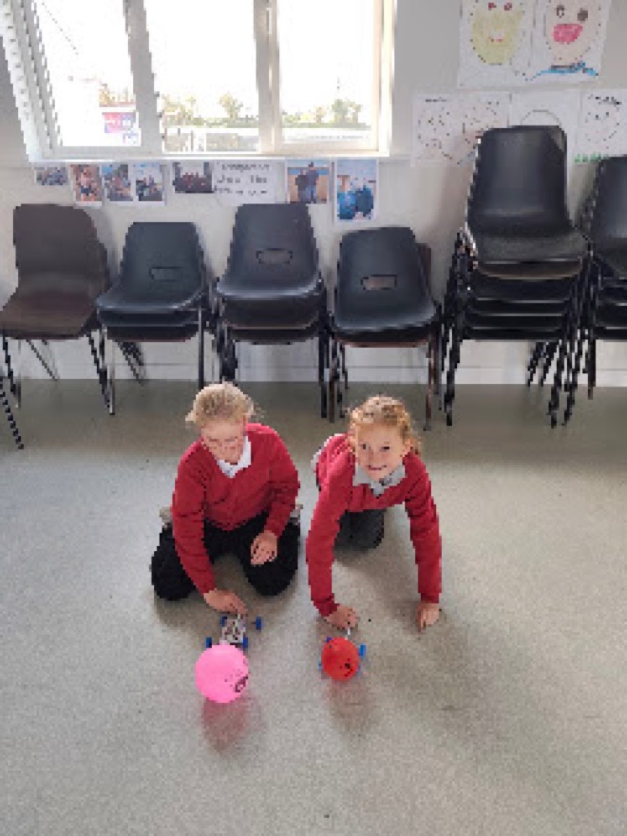 Pupils testing the balloon cars they built in the halla